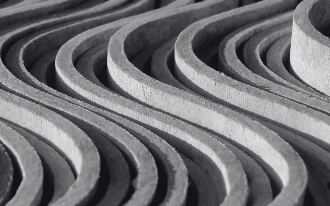 Monochromatic close-up of symmetrical wooden curves, showcasing texture and depth.